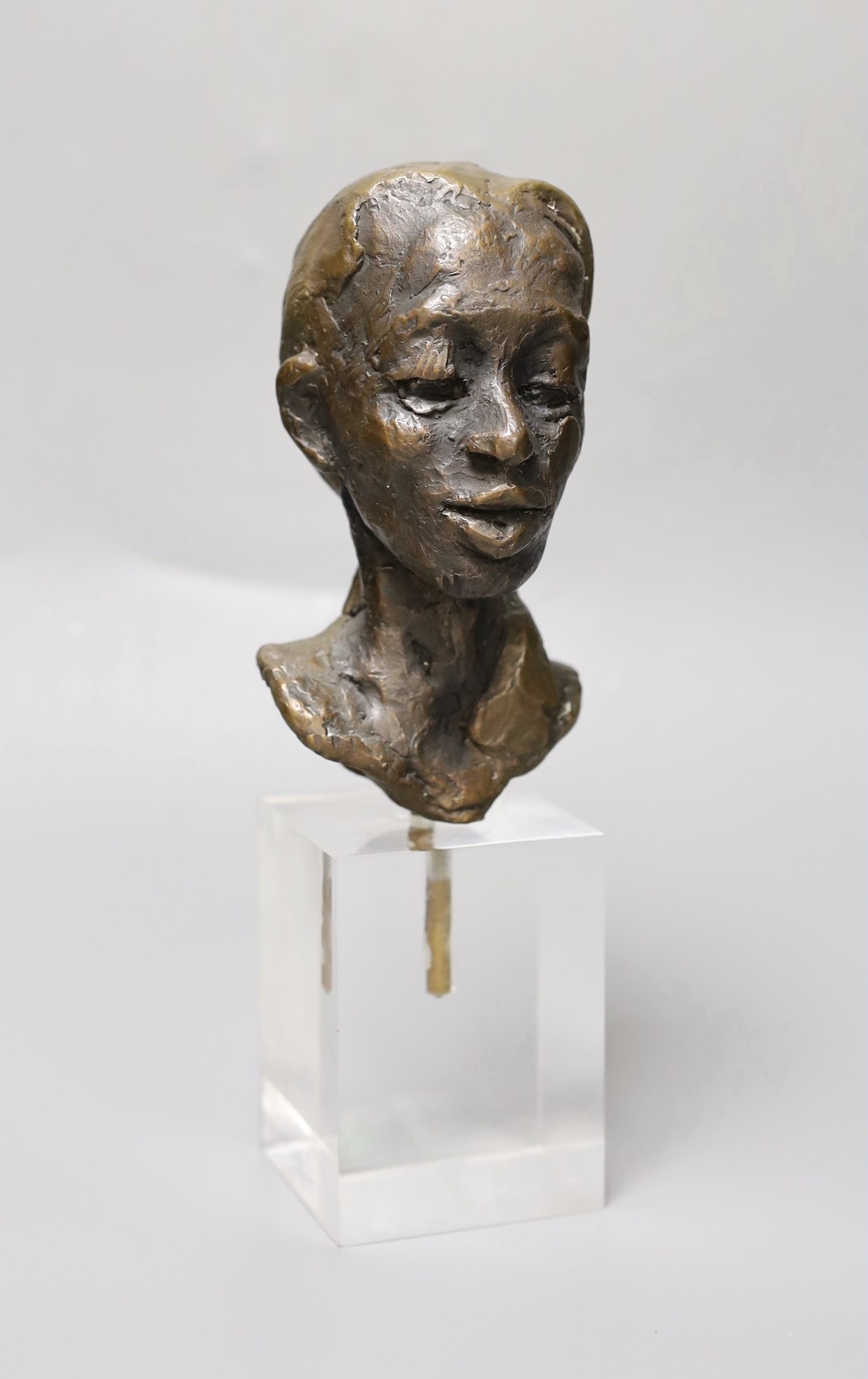 An abstract bronze bust of a girl, on perspex plinth, 24cm